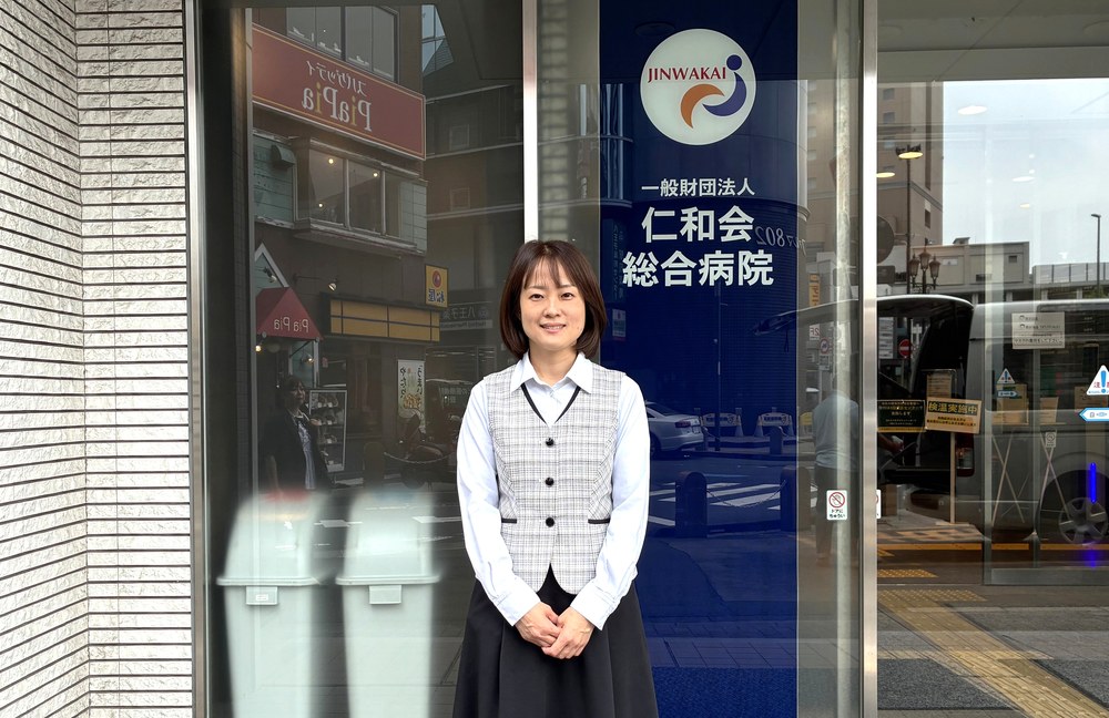 病院の入り口で取材に応じる金城様